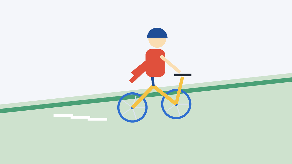 A gentle grassy slope with a child gliding downhill, feet up, on a pedal-less bike